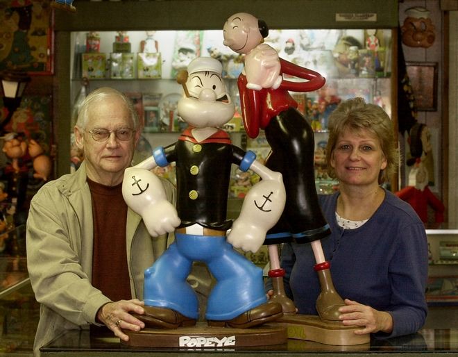 Ernie Schuchert, left, nephew to J. William Schuchert, the inspiration for Wimpy, a character from the Popeye comic strip, and Laurie Randall, right, co-owner of Spinach Can Collectibles and the Popeye Museum, pose inside the museum in downtown Chester, Ill., Wednesday, Jan. 14, 2004. Saturday, Jan. 17, is the 75th anniversary of Popeye the Sailor Man's comic-strip debut. (AP Photo/Charles Rex Arbogast)